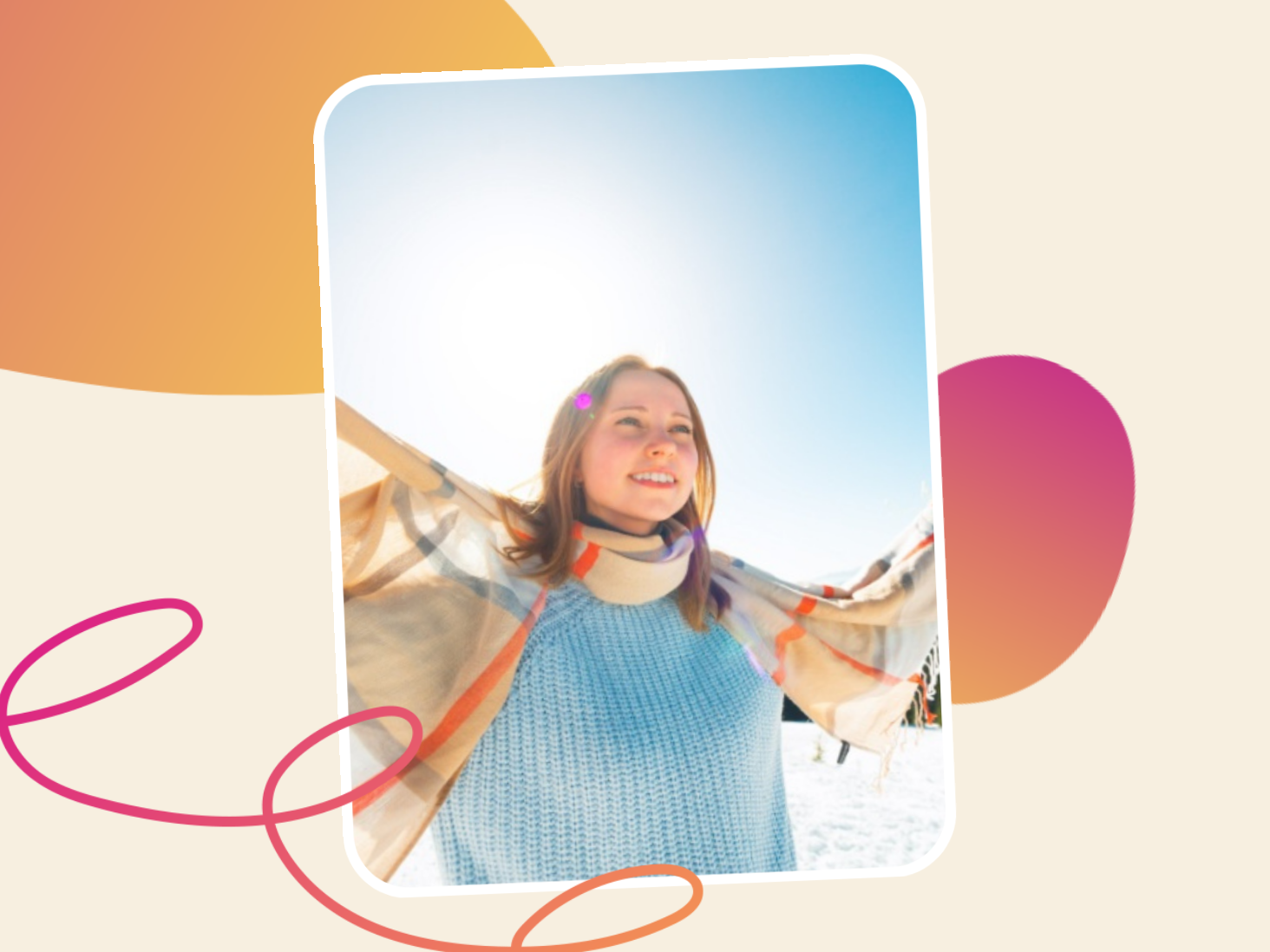 A smiling woman in a sweater and scarf stretches her arms wide outside on a bright, snowy day