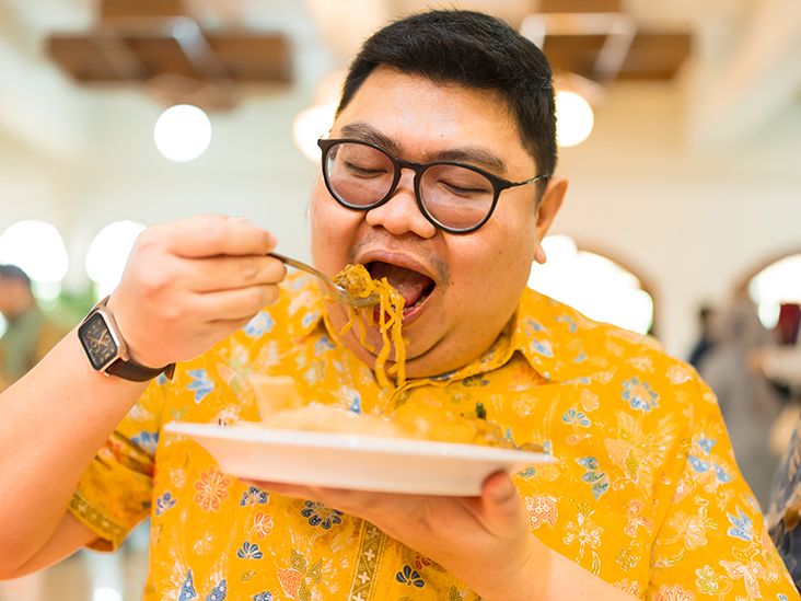 A person enjoying a plate of noodles