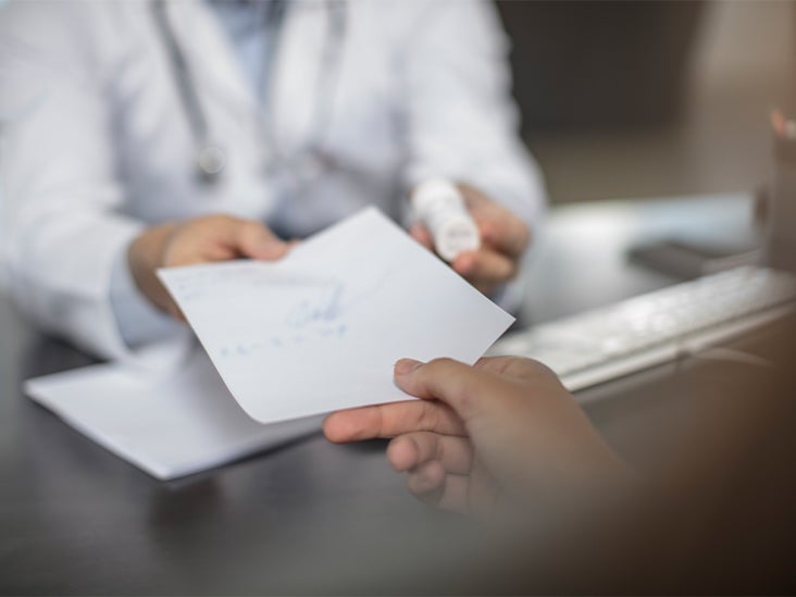 A doctor handing a prescription to a patient