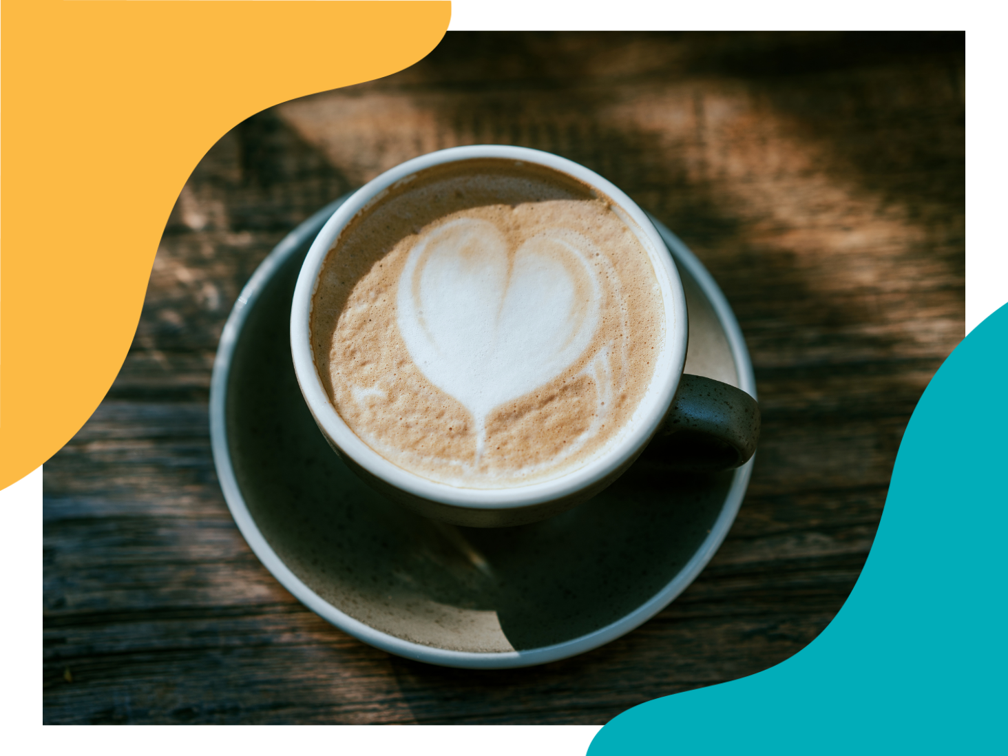 Latte with heart-shaped foam art on a saucer atop a wooden table
