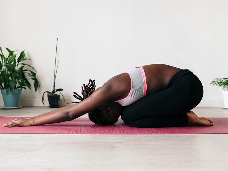 A person in a child's pose stretch on a yoga mat