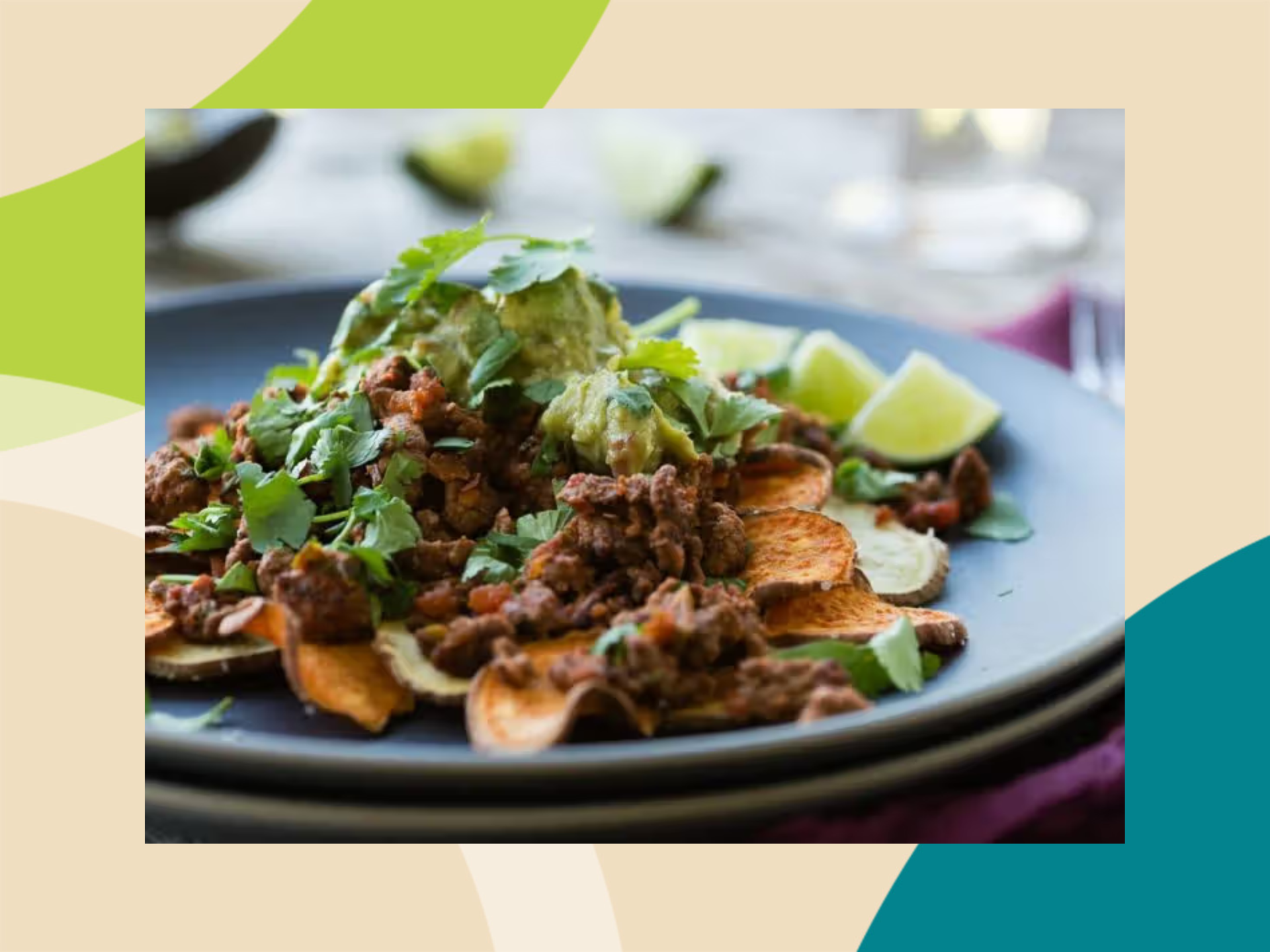 Sweet potato nachos topped with ground beef, guacamole, cilantro, and lime wedges